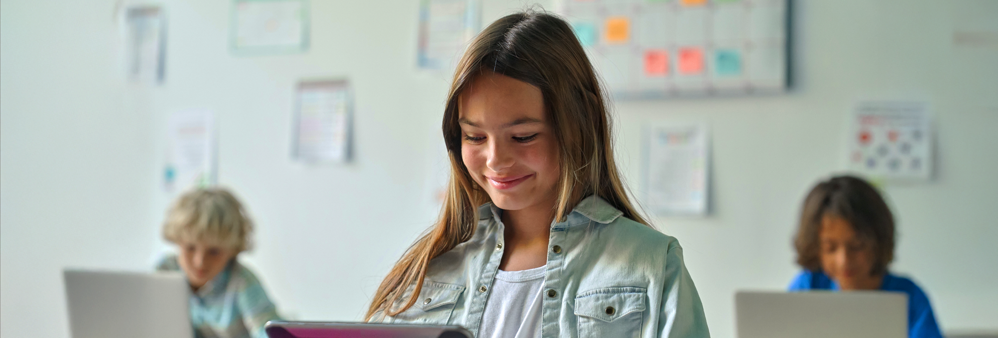 Eine Schülerin mit Tablet hält einen Vortrag vor der Klasse